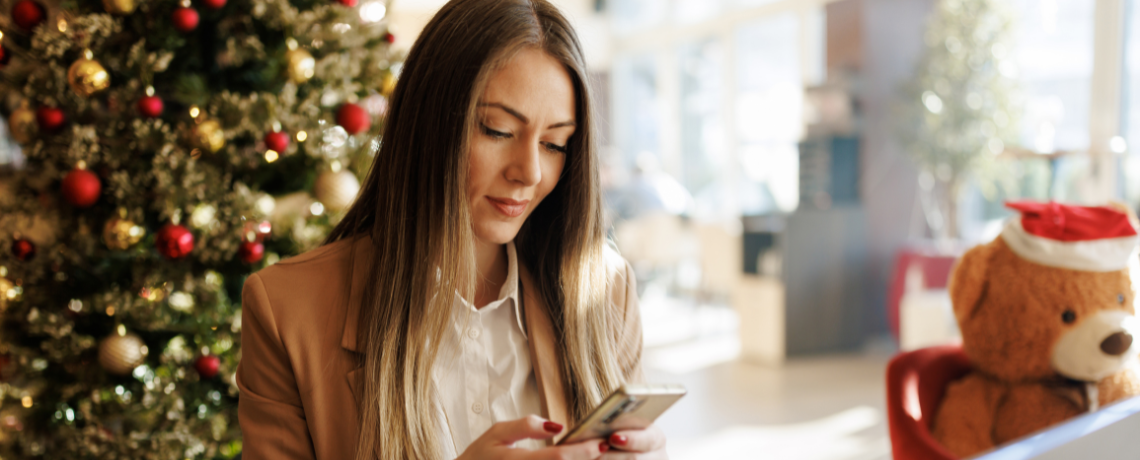 woman on phone by holiday decorations
